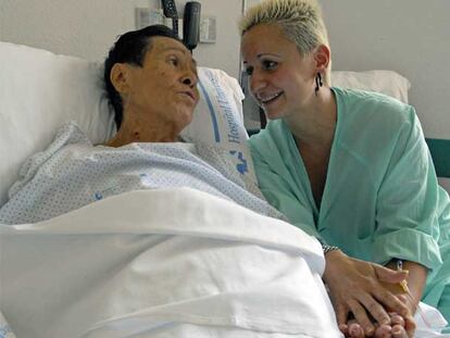 Susana Yzpisua coge las manos de su madre, convaleciente tras un trasplante de hígado.