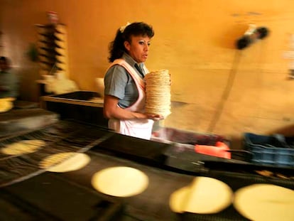 Una trabajadora recoge tortillas recién horneadas en una tienda de la ciudad de México.