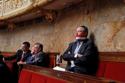 El diputado francés Alain Dupont-Aignan protesta, con la bandera como mordaza,  durante el discurso del primer ministro Francois Fillon en la Asamblea Nacional. Fillon ha admitido que su Gobierno mantuvo contactos con emisarios del líder libio Muamar el Gadafi