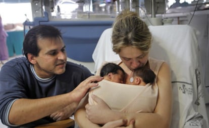 Almudena aplica, acompañado de su pareja, el <b><i>método canguro</b></i> a sus gemelos prematuros en la sala de neonatos del hospital La Fe.