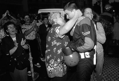 Una mujer abraza a un policía autonómico vasco (ertzaina) mientras custodiaba la sede de HB en Ermua.