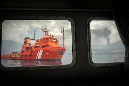 Buque de salvamento marítimo que forma parte del dispositivo de emergencia y la fumarola del volcán de Cumbre Vieja visto desde el interior de la patrullera de la Guardia Civil de La Palma.