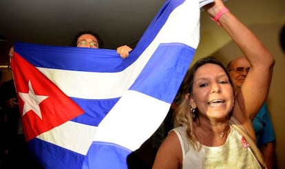 Un grupo de personas porta una bandera cubana.