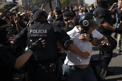 Un manifestant independentista és bloquejat per agents dels Mossos d'Esquadra.