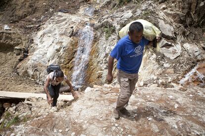 Guadalupe y su esposo escalan las rocas en el camino de vuelta a casa. Ella está enferma. Tardan más de una hora a pie.