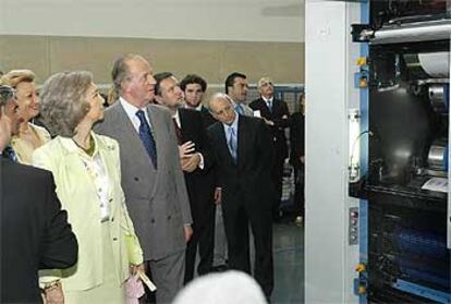 Los Reyes observan la maquinaria del periódico durante su recorrido por las nuevas instalaciones.