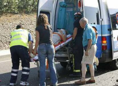 Miembros de la Cruz Roja evacuan a una de las personas heridas en el accidente.