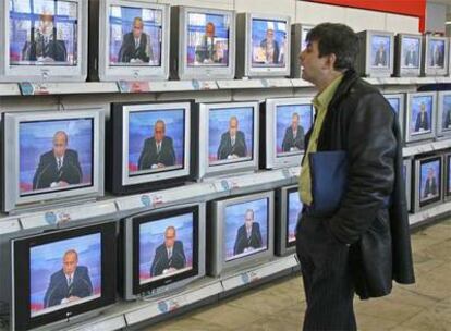 Un ciudadano observa la rueda de prensa de Putin en una tienda de Moscú