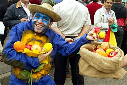 Un agricultor español muestra varias frutas durante la manifestación celebrada ayer en Bruselas