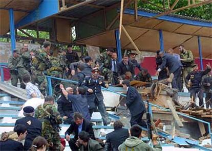 En medio de la confusión tras el estallido de la bomba, algunas personas tratan de rescatar el cuerpo del presidente checheno.