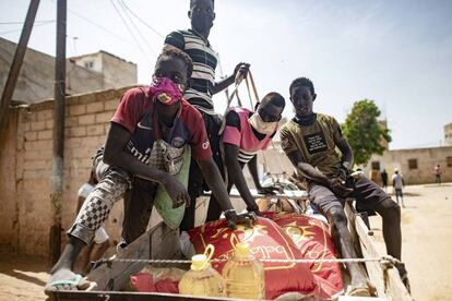 Una familia senegalesa transporta en su carro la comida, incluido arroz, azúcar y aceite, que ha recibido en un reparto de alimentos organizado por el Gobierno para los afectados por el impacto económico del nuevo coronavirus. Barrio de Guinaw Rails, Dakar, Senegal, 28 de abril de 2020.