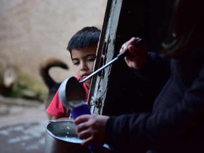 Una mujer sirve arroz con leche a un niño de escasos recursos, en Quilmes (Argentina), el 28 de mayo de 2020.