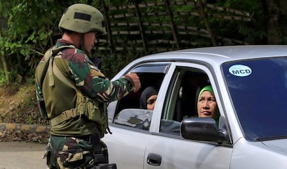 Un militar revisa los documentos de civiles en un puesto de bloque en Marawi, en el sur de Filipinas, donde ha sido declarada la ley marcial por la amenaza yihadista.