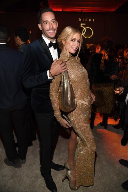 Paris Hilton, vestida de dorado, también acudió al cumpleaños de Diddy y allí posó con un amigo.