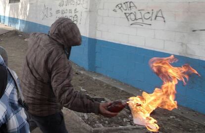 Un joven lanza un cóctel molotov.