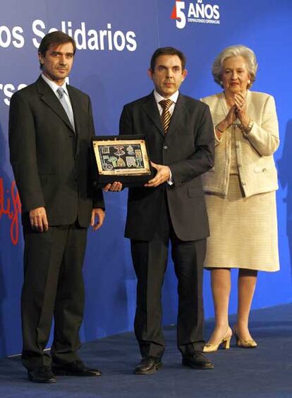 Jorge Flo y Manuel Dávila, muestran el galardón concedido por Ayuda en Acción, tras recibirlo de manos de la infanta Pilar de Borbón.