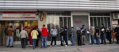 Decenas de personas esperan su turno ante una oficina del antiguo INEM en el madrile&ntilde;o barrio de Santa Eugenia. 