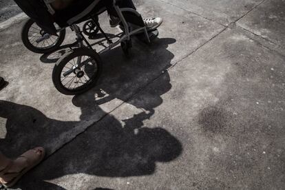 Sombra de Margarita Garfias empujando la silla de su hijo Carlos.