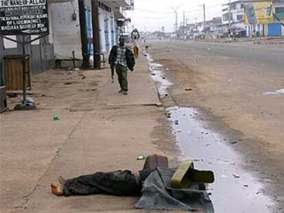 Un muerto yace tapado por una caja vacía de munición en los suburbios de Monrovia, la capital de Liberia.