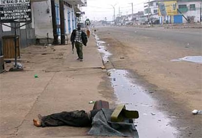 Un muerto yace tapado por una caja vacía de munición en los suburbios de Monrovia, la capital de Liberia.