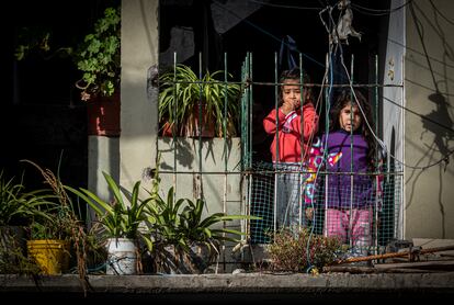 Niñas miran por la ventana de su casa en la villa.