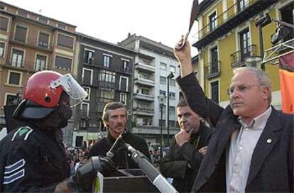 Un <i>ertzaintza</i> trata de impedir que AuB desarrolle su acto electoral en Tolosa.