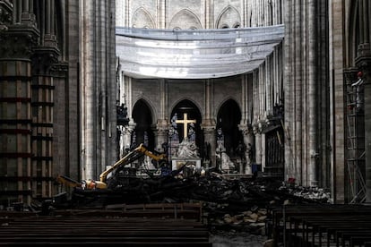 Um pequeno robô, ajudado por um braço mecânico e uma câmera de alta definição, busca indícios entre os restos carbonizados do telhado que ainda jazem ainda no chão da catedral.