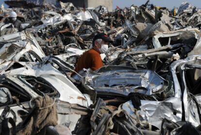 Un hombre busca su coche entre cientos de vehículos destruidos en Rikuzentakata.