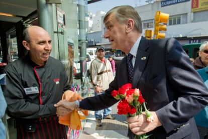 El socialista Hermes Binner regala flores a los vecinos de Buenos Aires.