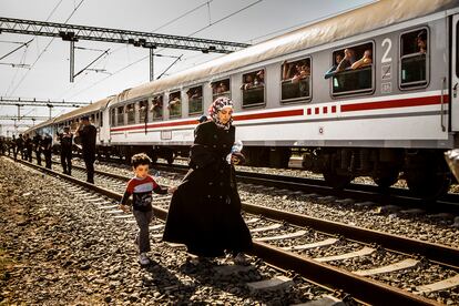 Una madre y su hijo llegan a la estación de tren tras caminar unos kilómetros desde Sid, en la frontera Serbia.