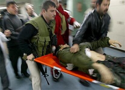 Hombres armados palestinos trasladan el cuerpo de uno de los muertos durante el ataque israelí en Gaza de esta noche.