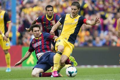 El delantero argentino Lionel Messi (i) intenta quitarle el balón a Gabriel Fernández.