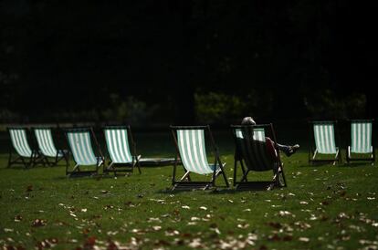 Un visitante disfruta del sol de otoño un una de las sillas del parque St James en el centro de Londres, el 30 de septiembre.