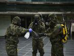 Militares del Regimiento América 66 de Pamplona se lavan los guantes después de desinfectar un establecimiento durante la Operación Balmis en Pamplona (Navarra).  