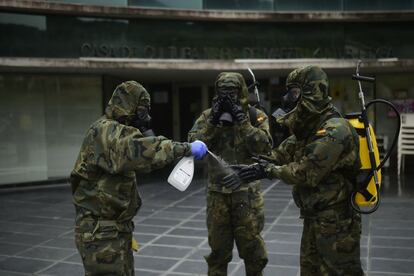 Militares del Regimiento América 66 de Pamplona se lavan los guantes después de desinfectar un establecimiento en la capital navarra el pasado 22 de abril.