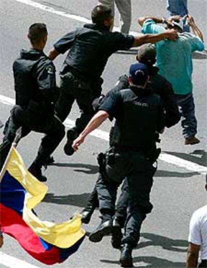 La policía detiene a un partidario de Chávez tras enfrentarse a un grupo de opositores, ayer en Caracas.