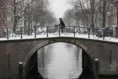 Un ciclista pasa por encima de un puente en uno de los canales del centro de Amsterdam.