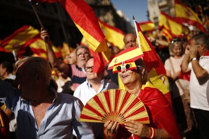 Una mujer con gafas y abanico con los colores de la bandera de Espana protesta durante la manifestación.