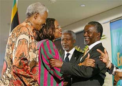 Nelson Mandela y su esposa, Graça Machel, saludan a Thabo Mbeki en presencia de Kofi Annan, ayer en Johanesburgo.