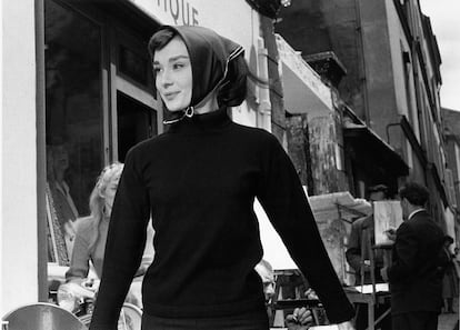Audrey Hepbburn, 1956. Los personajes de Audrey Hepburn fueron un puente entre el cine y la moda: lo que vestía la actriz en pantalla era tan relevante como sus diálogos. En Funny Face alterna piezas de alta costura (creadas por Givenchy) con básicos que se volvieron icónicos, como los pantalones pitillo negros, el jersey de cuello alto ajustado y las bailarinas planas. Este “uniforme” minimalista revolucionó la moda femenina de la época y el detalle del pañuelo en la cabeza quedó para siempre en el imaginario colectivo. (Bert Hardy/Picture Post/Hulton Archive/Getty Images)