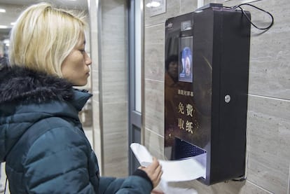 Dispensador de papel higiénico por reconocimiento facial en un baño público.