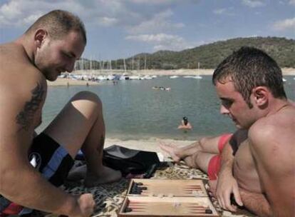 Unos bañistas juegan al <i>backgammon </i>en el pantano de San Juan.