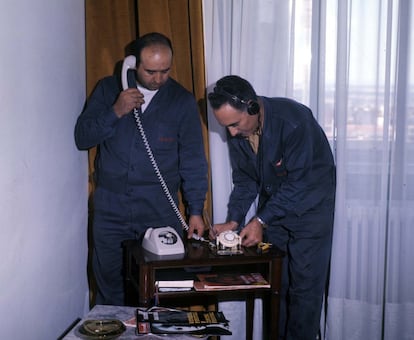 Dos técnicos de Telefónica instalan en una casa un teléfono Heraldo