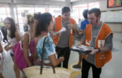 Dos trabajadores informan a los clientes sobre el corte de Rodalies, en la estación de L'Hospitalet.