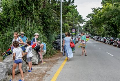 Decenas de coches aparcan en la carretera para ingresar a la zona de bosque y playa en Loredo. 