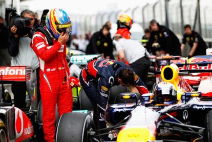 Fernando Alonso mira el monoplaza de Sebastian Vettel.