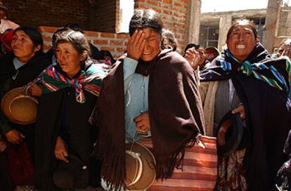 Familiares del alcalde linchado en Ilave (Perú) lloran ante la casa del regidor, en abril pasado.