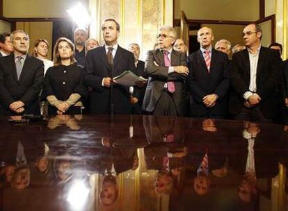 Alonso lee el comunicado conjunto de los grupos parlamentarios rodeado de los portavoces en el Congreso de los Diputados.