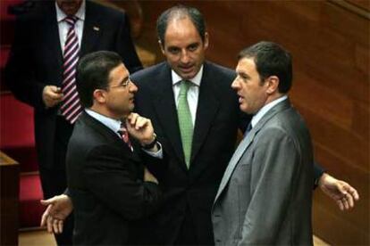 Castellano, Camps y Pla conversan en el centro del hemiciclo, durante un descanso en el debate parlamentario.