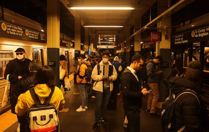 Decenas de pasajeros esperan el metro en una estación tras el tiroteo en Brooklyn. La policía busca a un hombre negro de 1,65 metros de altura y unos 80 kilos de peso, ataviado con una máscara de gas y un chaleco naranja de los utilizados en el sector de la construcción, que se cree huyó de la estación a pie tras el incidente.